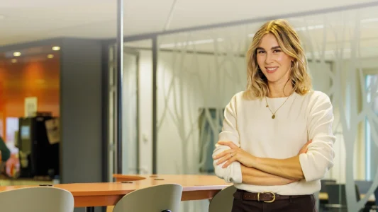 Decoratieve foto van een vrouwelijke collega van de Regionale Belasting groep, welke direct in de camera kijkt.