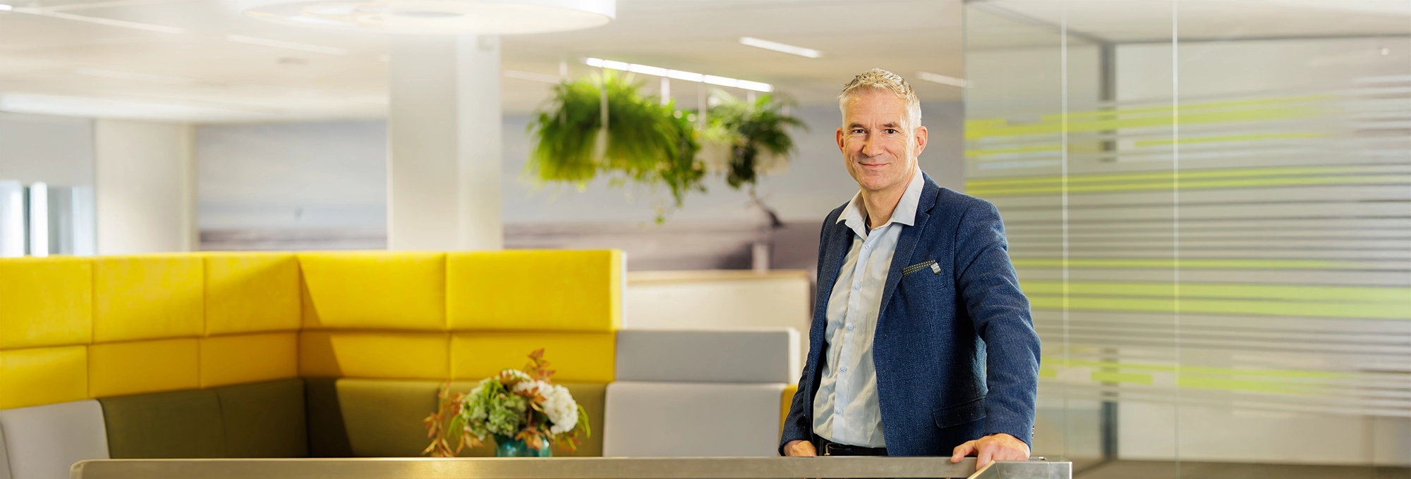 Decoratieve foto van een mannelijke collega van de Regionale Belasting groep, welke direct in de camera kijkt.